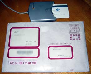 住基カードを挿したNTT ComのICカードリーダーSCR-301NTTComとe-Taxスタートキットの封筒